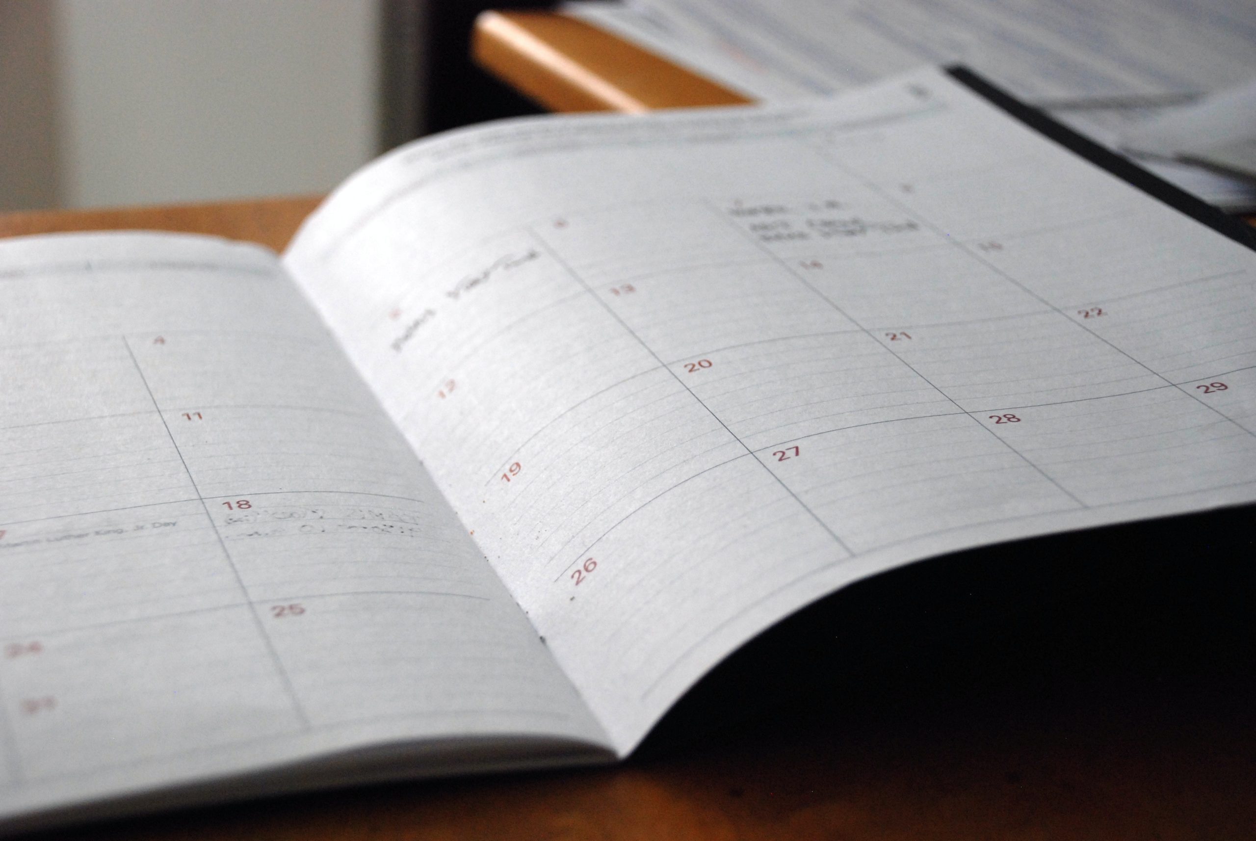 an image of an open notebook calendar with some items written in on a few dates