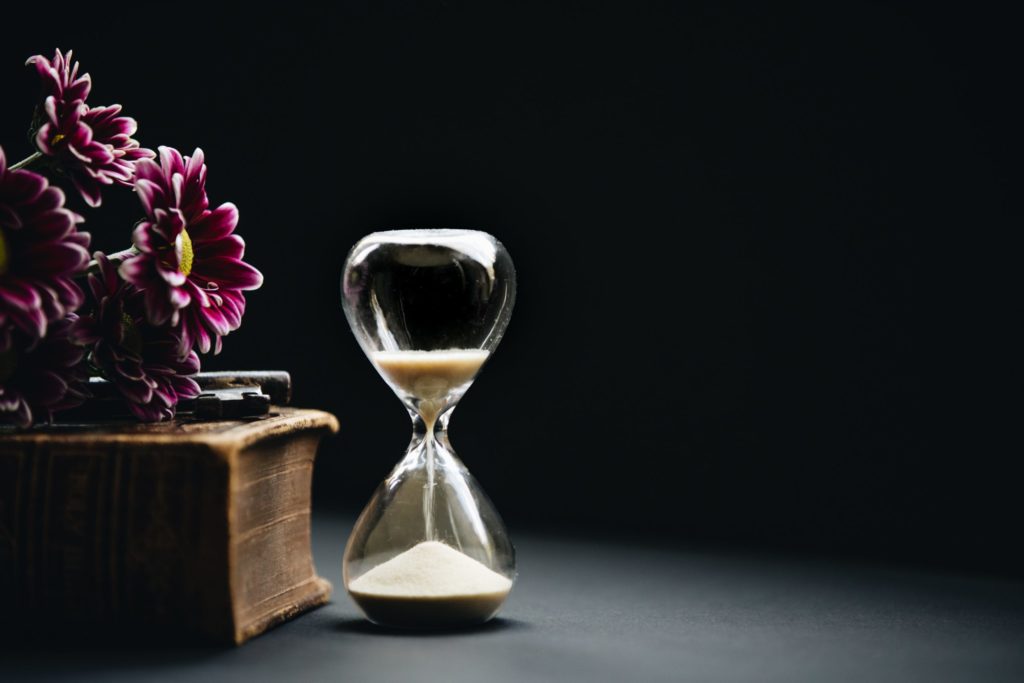 an hourglass against a black background, representing the passage of time